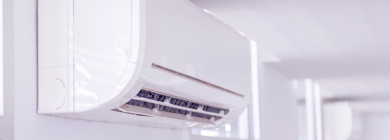 An air handler for a ductless mini-split is mounted to the wall.